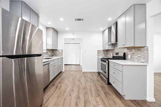 508 Kalmer St, Pasadena, TX 77502 - kitchen featuring appliances with stainless steel finishes, wall chimney exhaust hood, a sink, light countertops, and backsplash