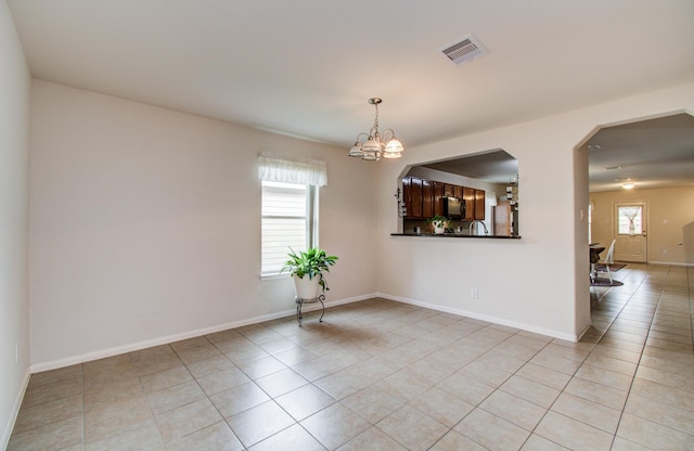 10406 Tenleyton Ln, Houston, TX 77075 - unfurnished room with light tile patterned floors, baseboards, and a chandelier