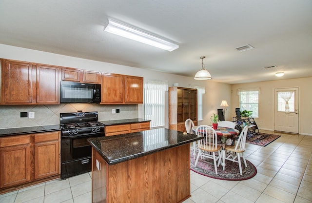 10406 Tenleyton Ln, Houston, TX 77075 - kitchen featuring black appliances, a center island, light tile patterned flooring, brown cabinets, and backsplash