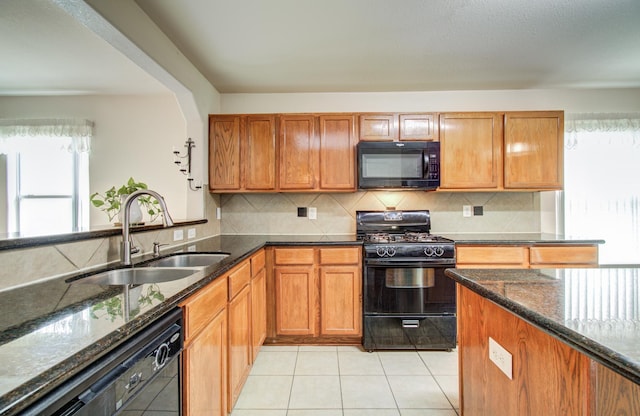 10406 Tenleyton Ln, Houston, TX 77075 - kitchen featuring black appliances, a sink, healthy amount of natural light, and dark stone countertops