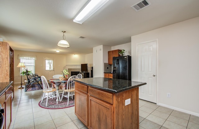 10406 Tenleyton Ln, Houston, TX 77075 - kitchen with black fridge, light tile patterned flooring, a kitchen island, baseboards, and pendant lighting
