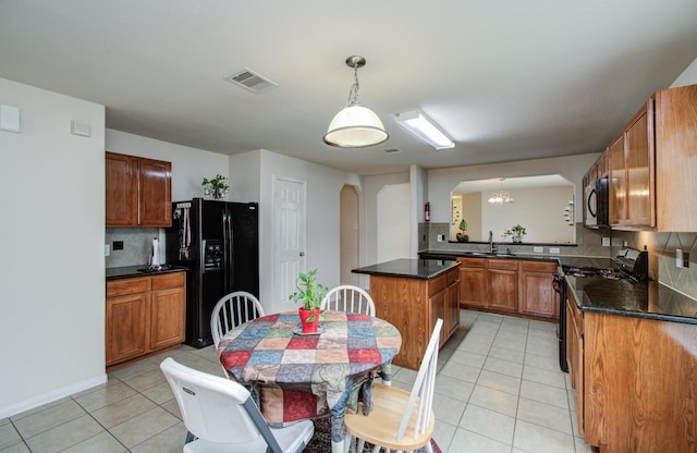 10406 Tenleyton Ln, Houston, TX 77075 - kitchen featuring black appliances, arched walkways, a sink, light tile patterned floors, and backsplash