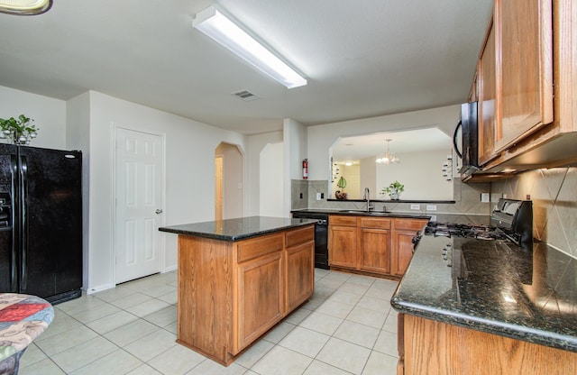 10406 Tenleyton Ln, Houston, TX 77075 - kitchen with black appliances, arched walkways, a sink, and light tile patterned flooring