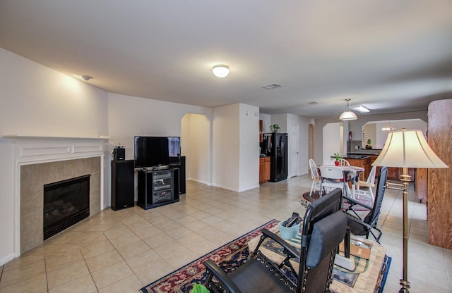 10406 Tenleyton Ln, Houston, TX 77075 - living room featuring light tile patterned floors, a tiled fireplace, and baseboards