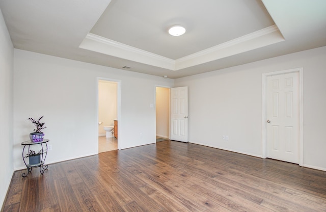 10406 Tenleyton Ln, Houston, TX 77075 - unfurnished bedroom featuring a tray ceiling, ornamental molding, wood finished floors, connected bathroom, and baseboards