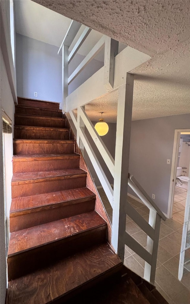 18 Townhouse Ln Unit 18, Trinity, TX 75862 - stairway with tile patterned flooring and a textured ceiling