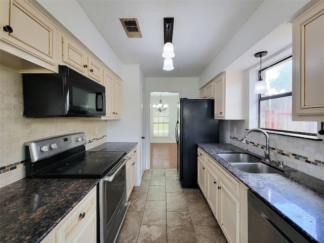 18515 Sweetmeadow Dr, Spring, TX 77379 - kitchen featuring black appliances, a sink, cream cabinetry, backsplash, and decorative light fixtures