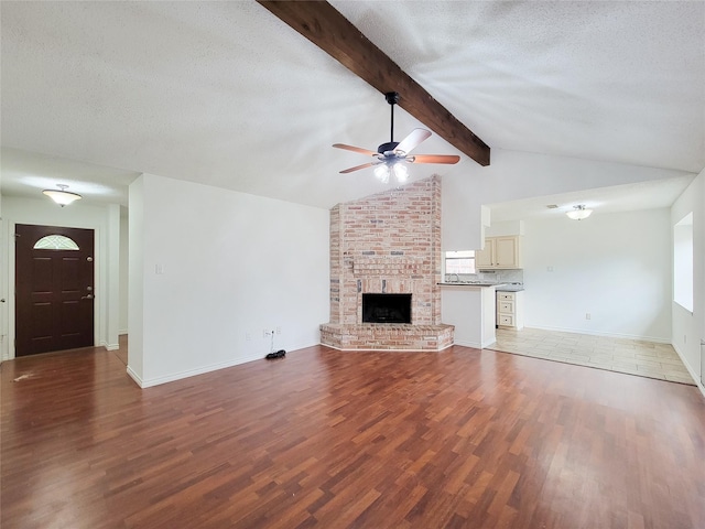 18515 Sweetmeadow Dr, Spring, TX 77379 - unfurnished living room with ceiling fan, wood finished floors, a textured ceiling, a fireplace, and baseboards