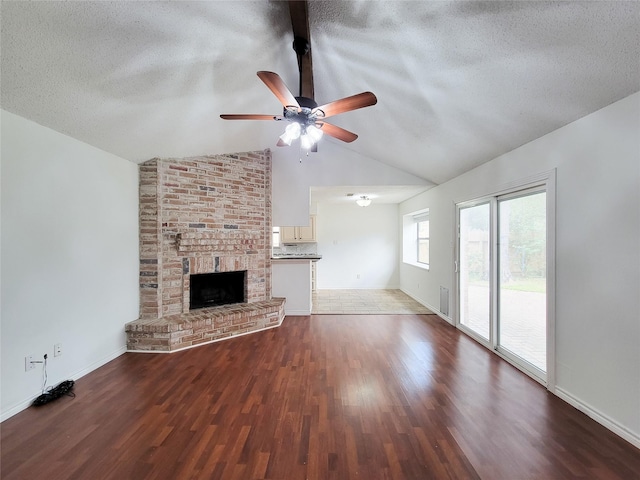 18515 Sweetmeadow Dr, Spring, TX 77379 - unfurnished living room with vaulted ceiling, a textured ceiling, ceiling fan, wood finished floors, and baseboards