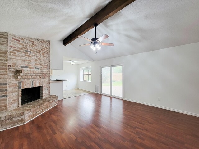 18515 Sweetmeadow Dr, Spring, TX 77379 - unfurnished living room with ceiling fan, baseboards, wood finished floors, a textured ceiling, and a brick fireplace