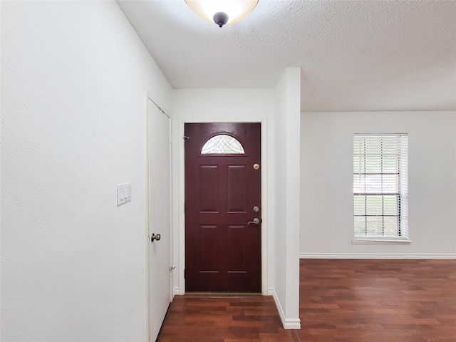 18515 Sweetmeadow Dr, Spring, TX 77379 - foyer featuring dark wood-style floors, baseboards, and a textured ceiling