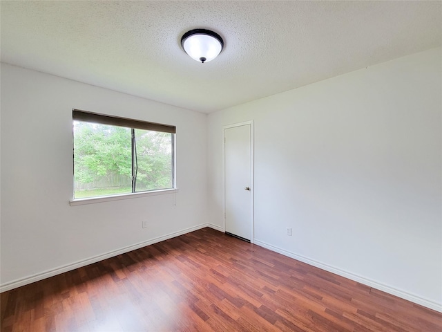 18515 Sweetmeadow Dr, Spring, TX 77379 - empty room with dark wood-style flooring, baseboards, and a textured ceiling