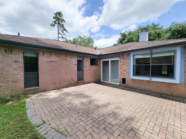 18515 Sweetmeadow Dr, Spring, TX 77379 - back of house with a patio, brick siding, a chimney, and a shingled roof