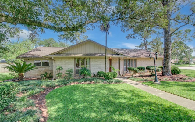 mid-century inspired home with a front yard and brick siding