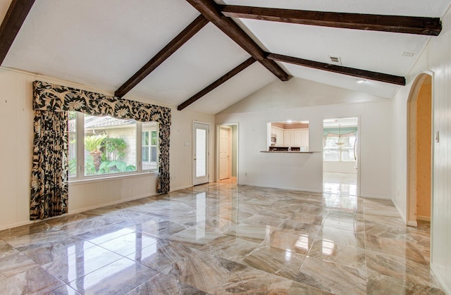 unfurnished living room with light marble finish floors and arched walkways