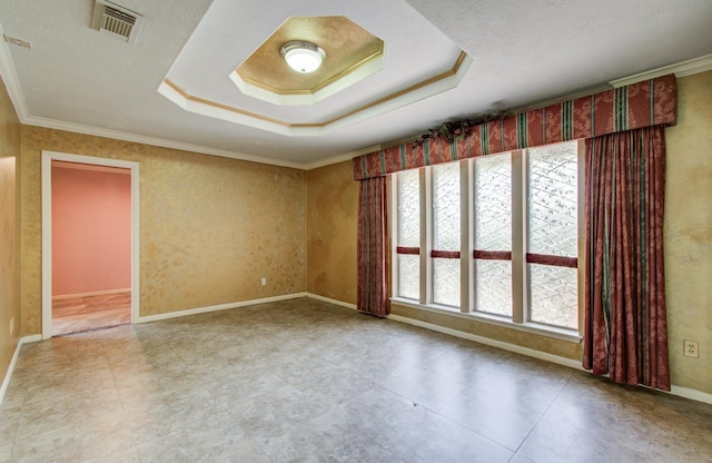 spare room featuring a tray ceiling, crown molding, and baseboards