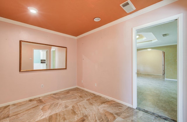 unfurnished room featuring arched walkways, crown molding, and baseboards