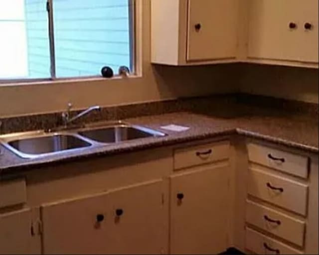 406 Poinsetta St, Lake Jackson, TX 77566 - kitchen featuring a sink, dark countertops, and white cabinets