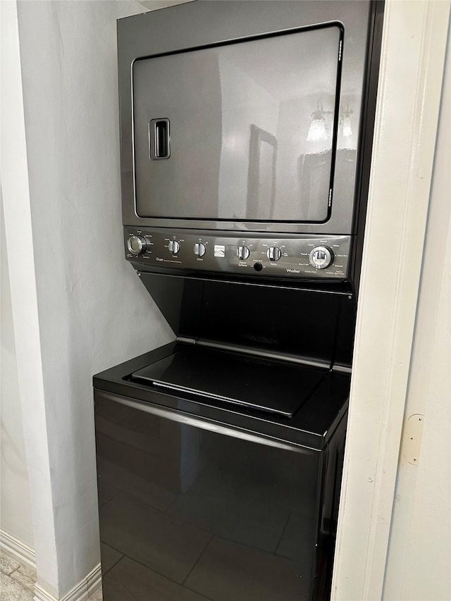 clothes washing area featuring estacked washer and dryer and baseboards