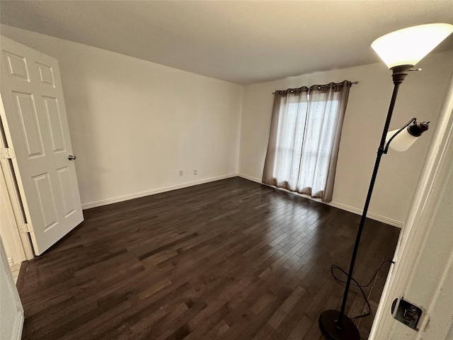 unfurnished bedroom with dark wood-style floors and baseboards