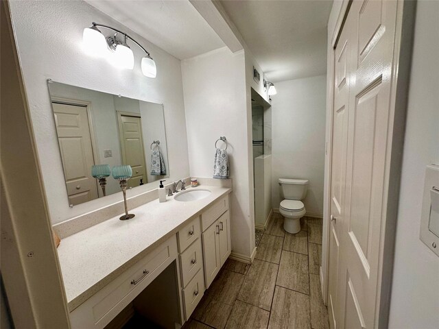full bath with vanity, toilet, and wood finish floors