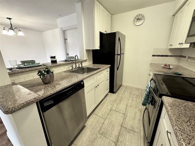 kitchen with appliances with stainless steel finishes, a sink, wood tiled floors, and white cabinets