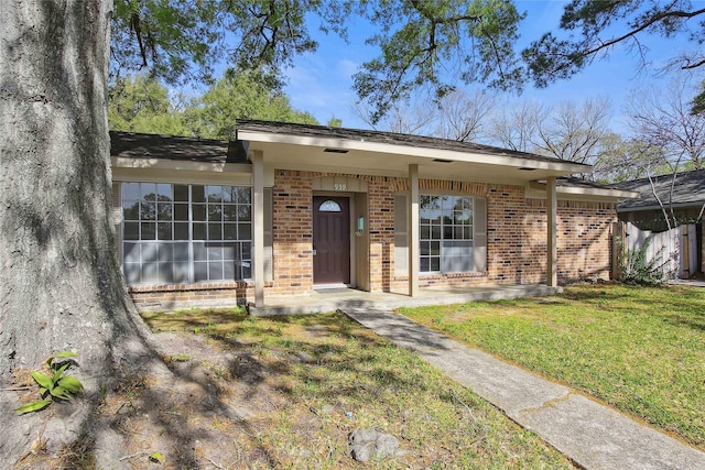 ranch-style house featuring brick siding and a front yard