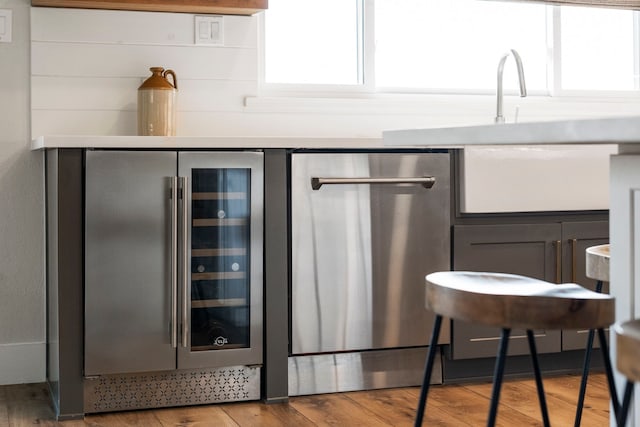 30 N Curlew St, La Marque, TX 77568 - bar area featuring beverage cooler, stainless steel dishwasher, wood finished floors, and plenty of natural light