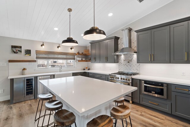 30 N Curlew St, La Marque, TX 77568 - kitchen with wall chimney exhaust hood, appliances with stainless steel finishes, a sink, a breakfast bar, and open shelves