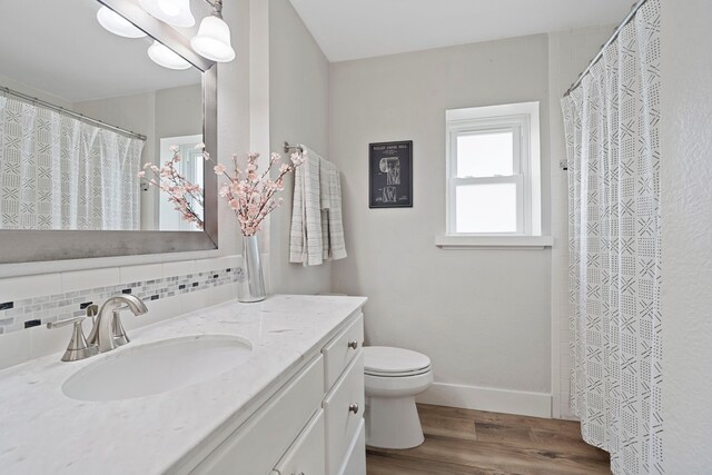 30 N Curlew St, La Marque, TX 77568 - full bath featuring wood finished floors, toilet, vanity, backsplash, and baseboards