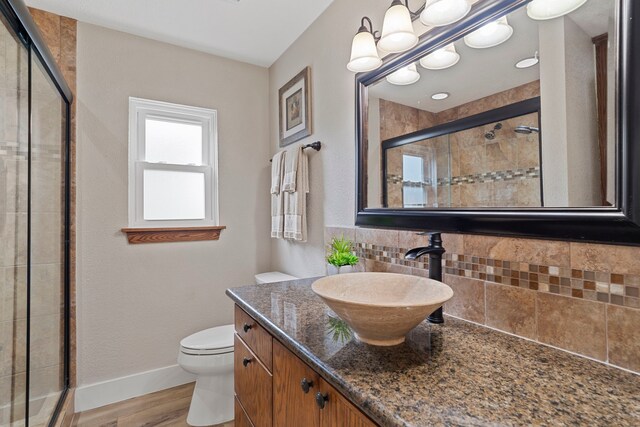 30 N Curlew St, La Marque, TX 77568 - bathroom with backsplash, a shower stall, wood finished floors, toilet, and vanity