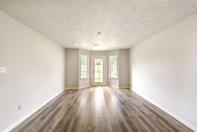 6613 Whitton Dr, Houston, TX 77085 - unfurnished room with wood finished floors, baseboards, a textured ceiling, and recessed lighting
