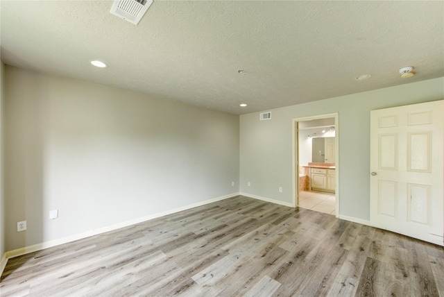 6613 Whitton Dr, Houston, TX 77085 - unfurnished room featuring light wood-type flooring, recessed lighting, a textured ceiling, baseboards, and a smoke detector