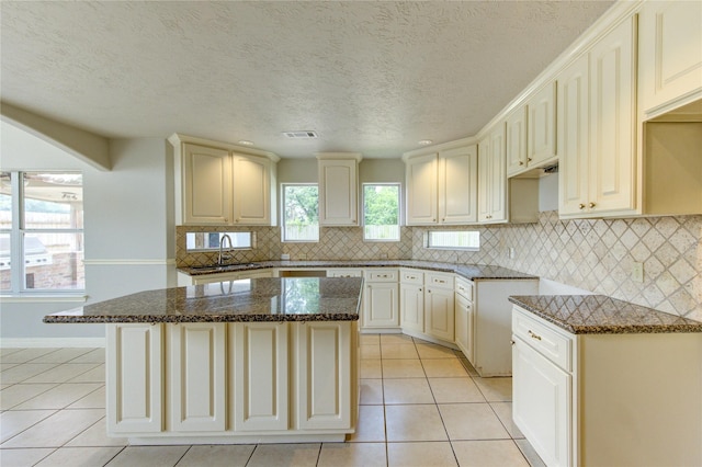 6613 Whitton Dr, Houston, TX 77085 - kitchen with a sink, light tile patterned flooring, dark stone countertops, tasteful backsplash, and a kitchen island