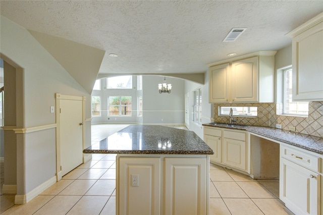6613 Whitton Dr, Houston, TX 77085 - kitchen with a sink, a chandelier, backsplash, light tile patterned floors, and cream cabinets