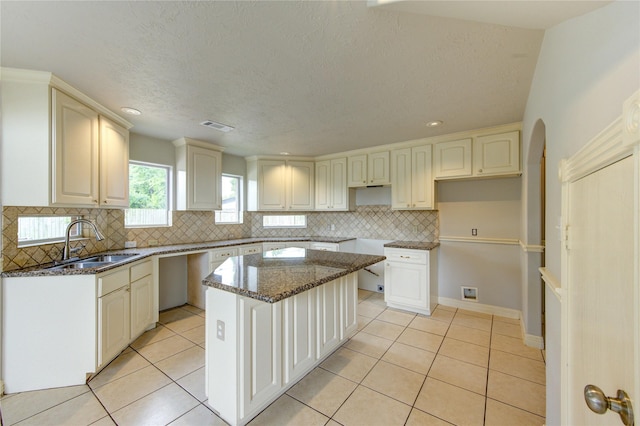 6613 Whitton Dr, Houston, TX 77085 - kitchen with a sink, light tile patterned flooring, decorative backsplash, dark stone counters, and recessed lighting