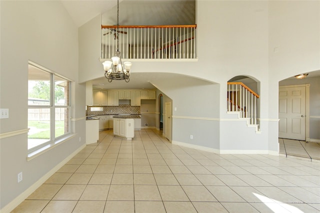 6613 Whitton Dr, Houston, TX 77085 - unfurnished living room featuring high vaulted ceiling, a chandelier, light tile patterned floors, and baseboards