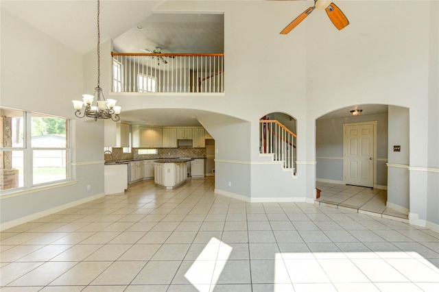 6613 Whitton Dr, Houston, TX 77085 - unfurnished living room with ceiling fan, high vaulted ceiling, light tile patterned floors, a chandelier, and baseboards
