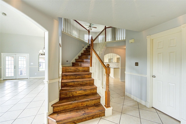 6613 Whitton Dr, Houston, TX 77085 - stairs featuring tile patterned flooring, arched walkways, ceiling fan, french doors, and baseboards