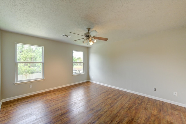 6613 Whitton Dr, Houston, TX 77085 - spare room featuring baseboards, a ceiling fan, dark wood-type flooring, and a textured ceiling