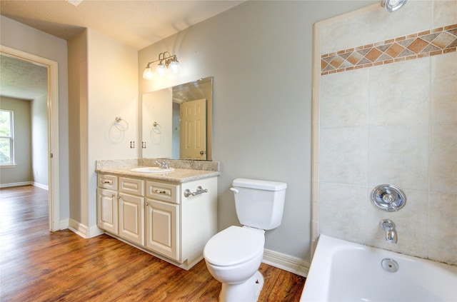 6613 Whitton Dr, Houston, TX 77085 - bathroom with wood finished floors, toilet, vanity, and tub / shower combination