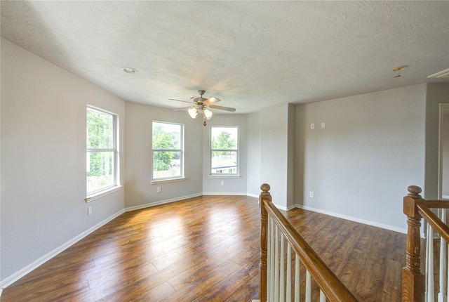 6613 Whitton Dr, Houston, TX 77085 - unfurnished room featuring healthy amount of natural light, a ceiling fan, dark wood-style flooring, a textured ceiling, and baseboards