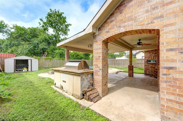 6613 Whitton Dr, Houston, TX 77085 - view of patio with area for grilling, a ceiling fan, a storage unit, an outbuilding, and a grill