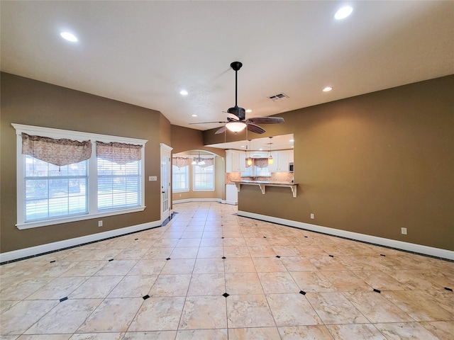 719 Partridge Ln, Eagle Lake, TX 77434 - unfurnished living room featuring recessed lighting, ceiling fan, baseboards, arched walkways, and light tile patterned flooring