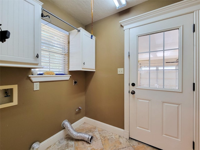 719 Partridge Ln, Eagle Lake, TX 77434 - laundry room featuring hookup for an electric dryer, baseboards, hookup for a washing machine, cabinet space, and a textured ceiling