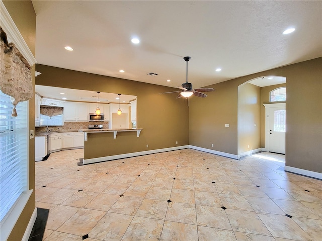 719 Partridge Ln, Eagle Lake, TX 77434 - unfurnished living room featuring recessed lighting, arched walkways, a ceiling fan, baseboards, and light tile patterned floors