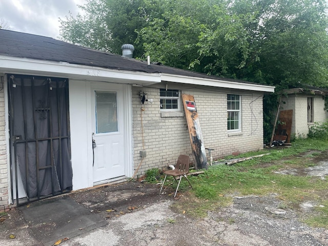 5118 Mallow St, Houston, TX 77033 - doorway to property featuring brick siding and roof with shingles