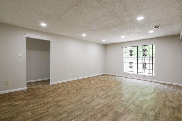 9923 Valley Sun Dr, Houston, TX 77078 - spare room featuring wood finished floors, a textured ceiling, recessed lighting, and baseboards