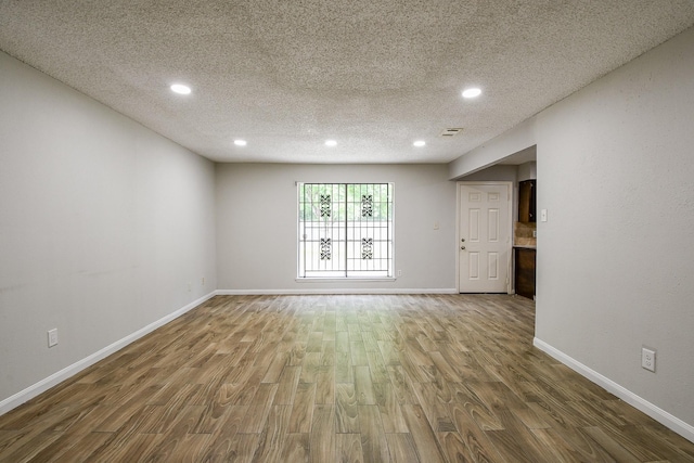 9923 Valley Sun Dr, Houston, TX 77078 - unfurnished room featuring wood finished floors, a textured ceiling, recessed lighting, and baseboards