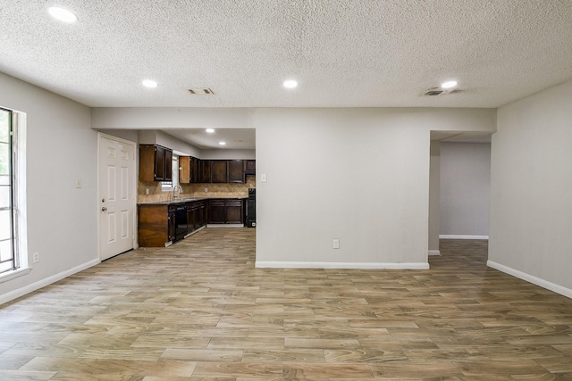 9923 Valley Sun Dr, Houston, TX 77078 - kitchen with light wood-type flooring, recessed lighting, dark brown cabinets, stove, and a textured ceiling